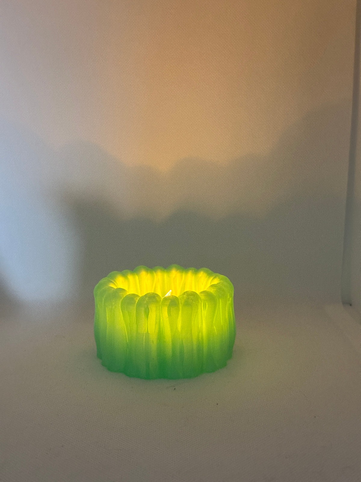 Organic Ribbed Tealight Holder neon green glowing tealight real product dimly lit atmospheric shot