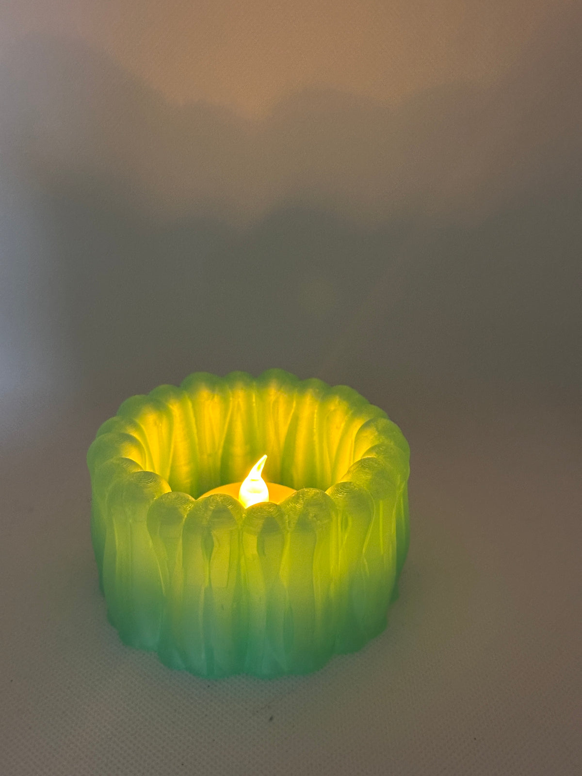Organic Ribbed Tealight Holder neon green glowing tealight real product wider atmospheric shot warm glow