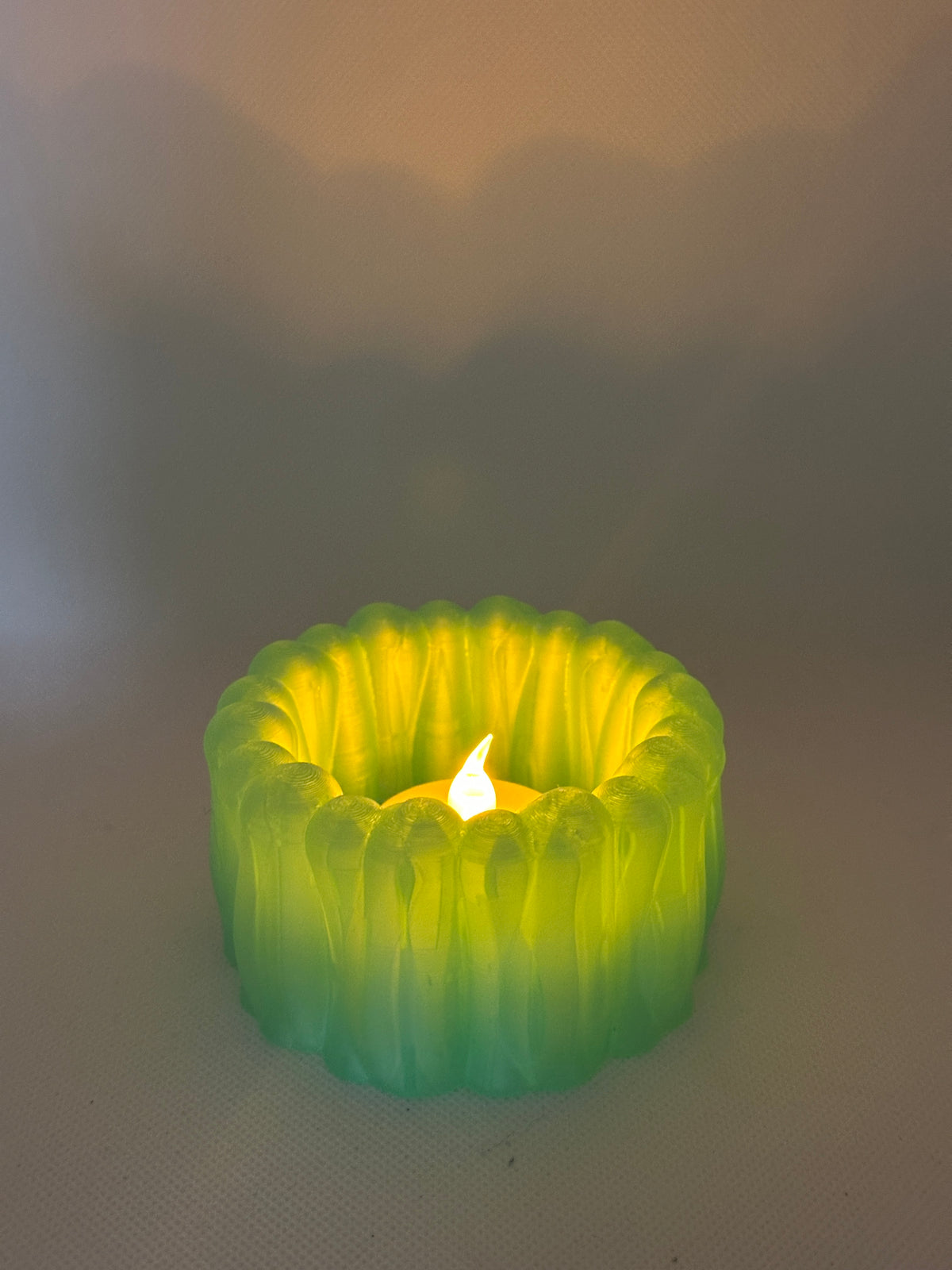 Organic Ribbed Tealight Holder neon green glowing tealight real product top down view warm flame visible