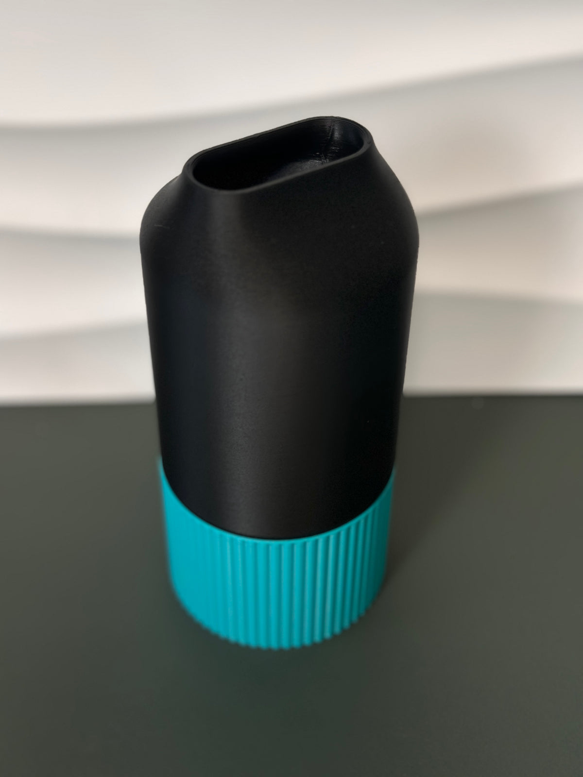 Elegant Two-Part Slot Vase black teal real product wider lifestyle shot on dark grey surface