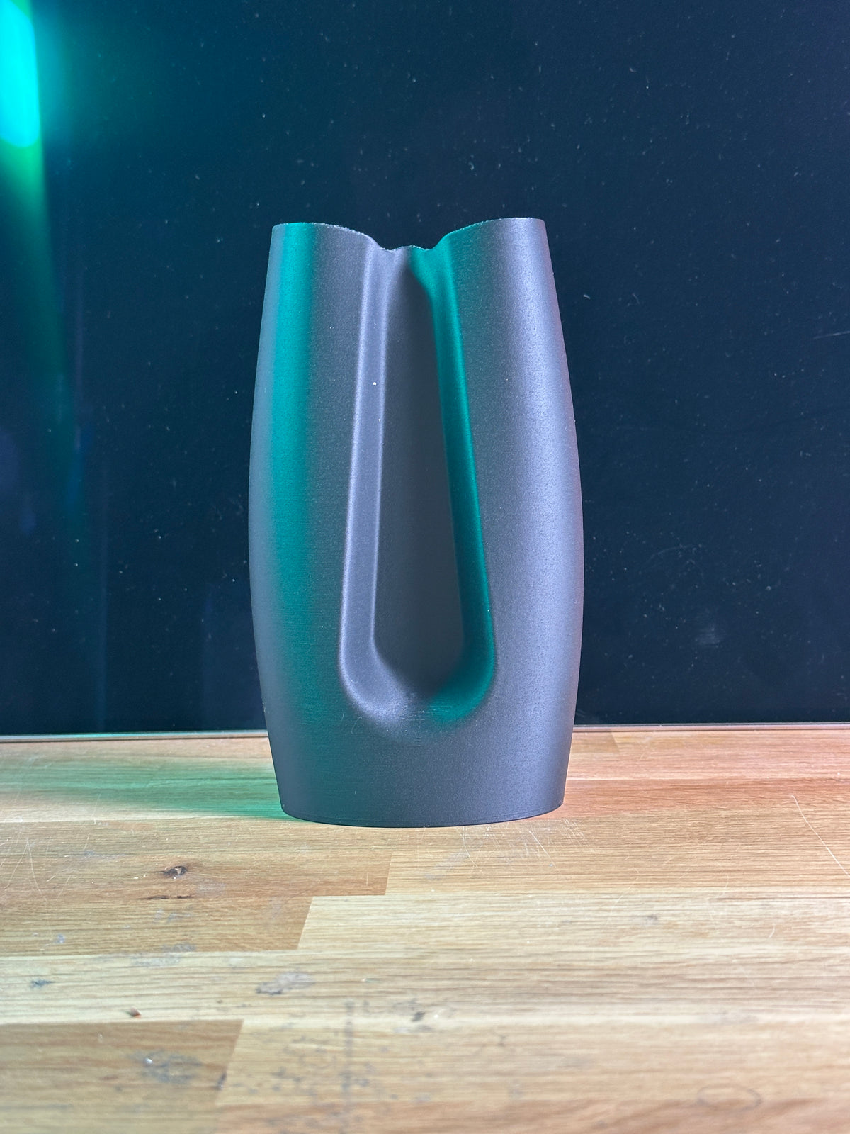 Modern Curved Minimalist Vase dark grey real product on wooden table dark background