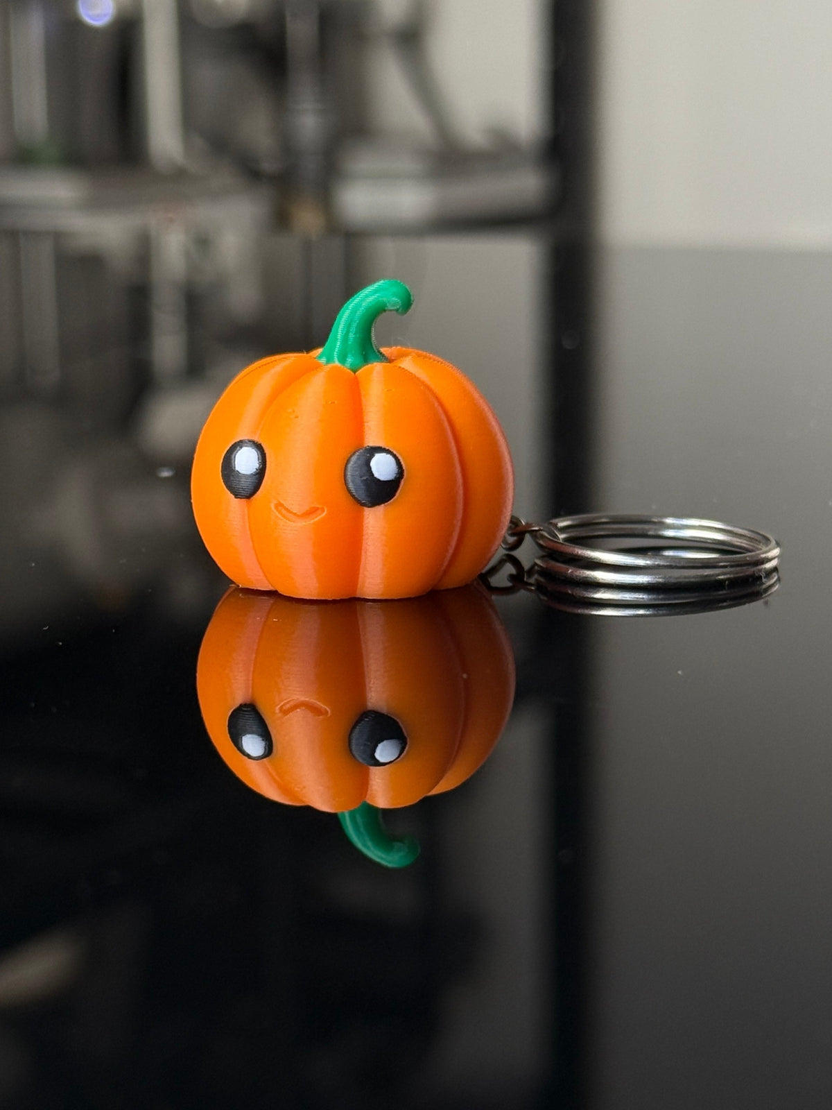 Close view of pumpkin keychain face and green stem
