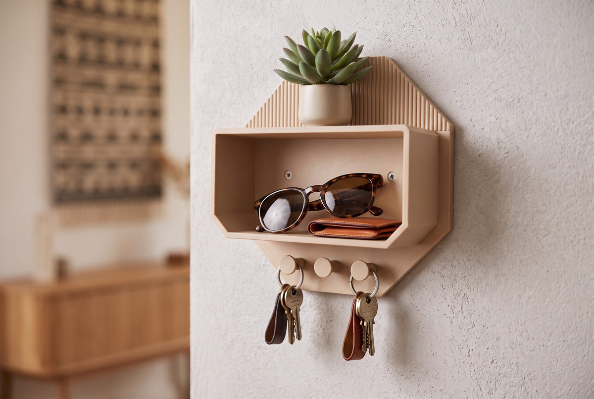 Octagonal beige wall shelf with a plant, folded wallet, sunglasses and keys on hooks