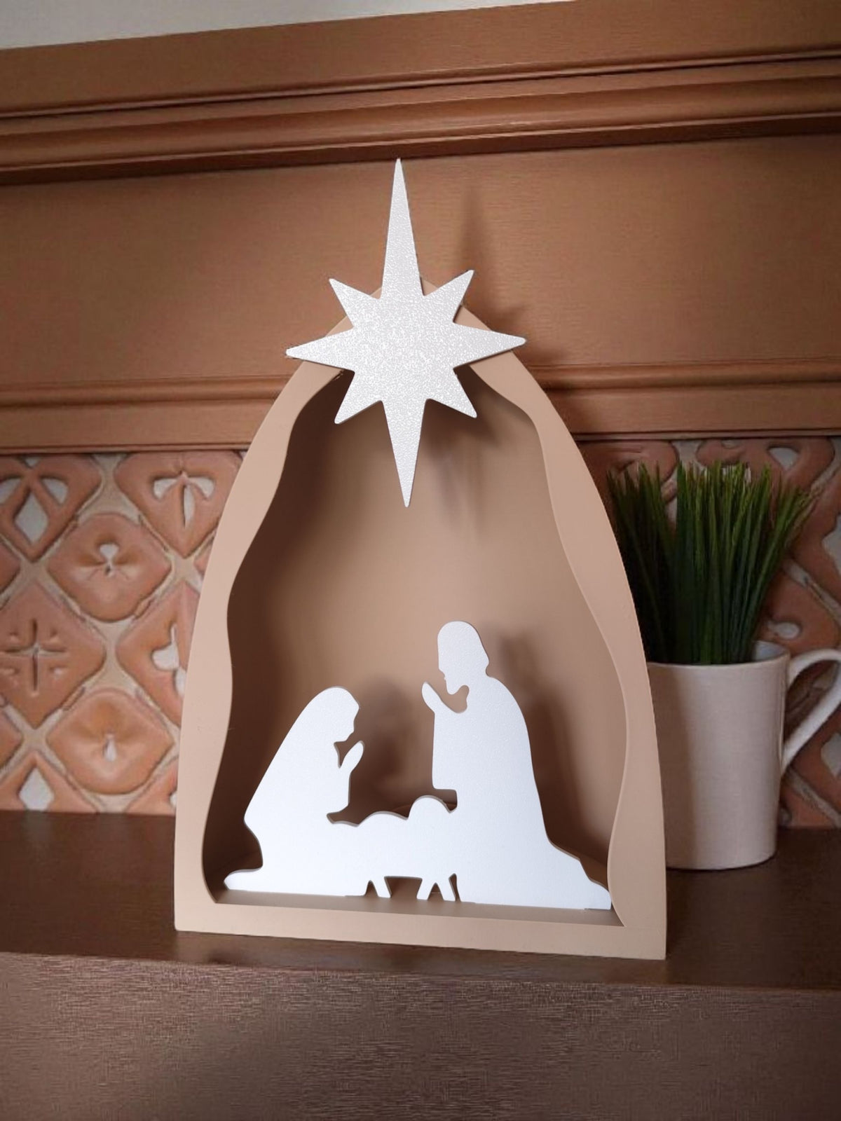 Close-up of star topper on nativity scene arch against wooden wall background