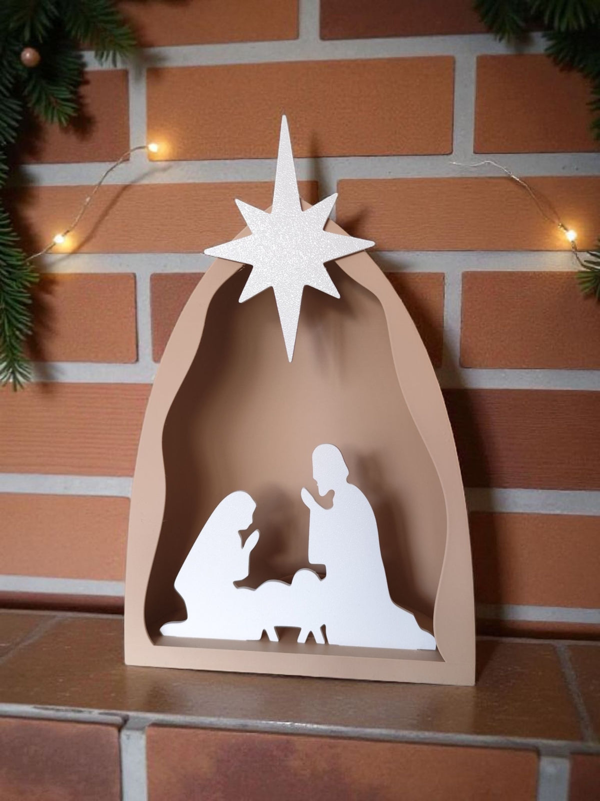 Close-up of star on nativity scene with pine cones and fairy lights on shelf above