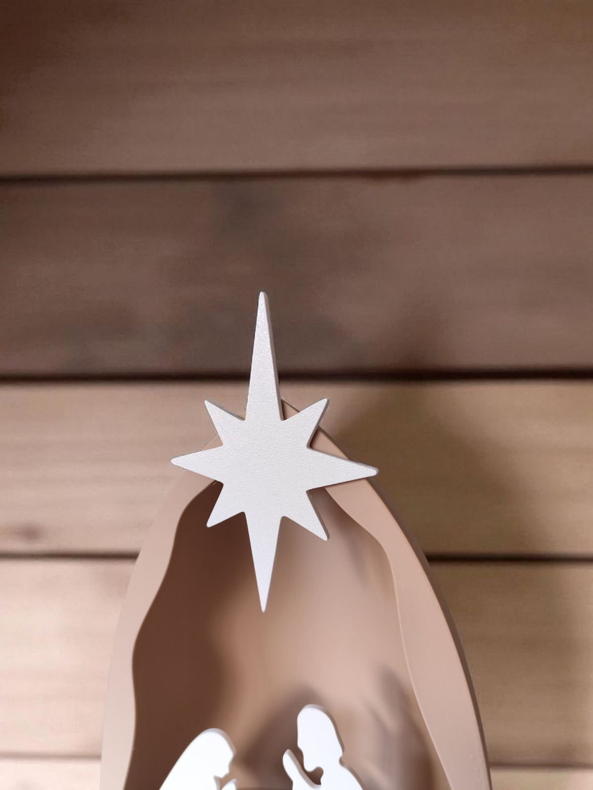 Side profile of nativity scene on wooden table beside open book and coffee cup