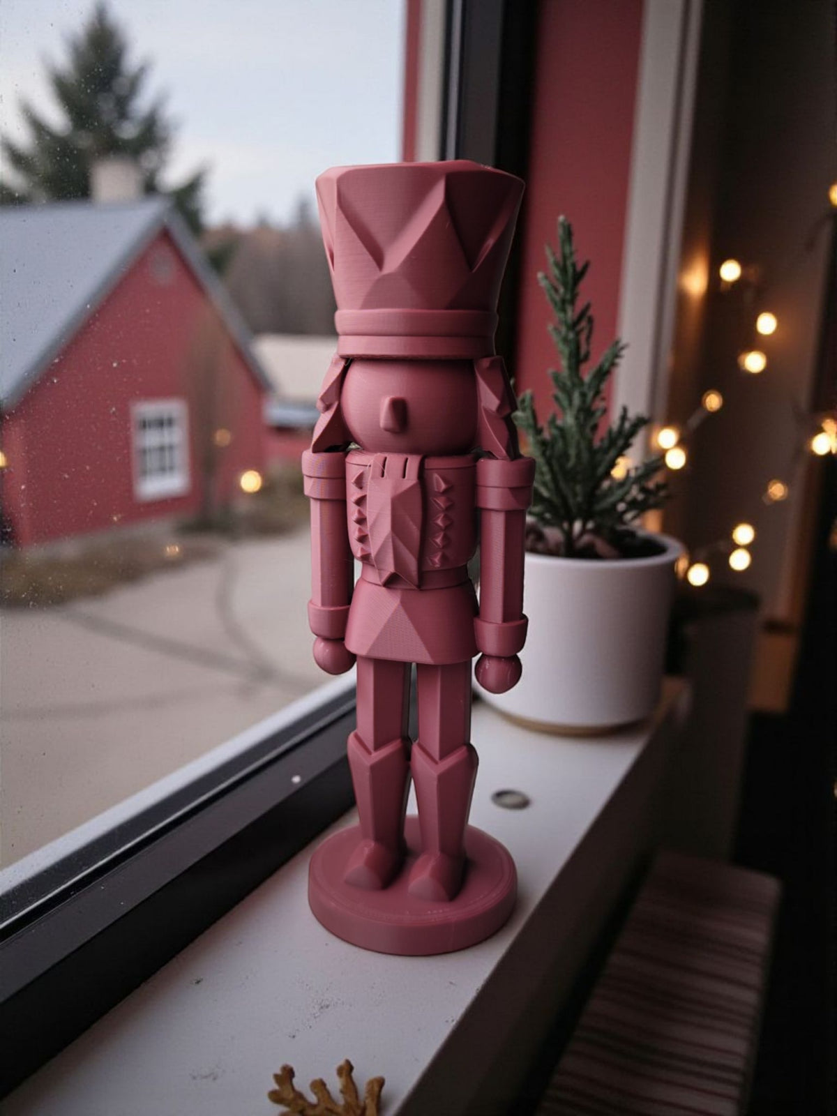 Dusty rose nutcracker on wooden dining table clean product shot