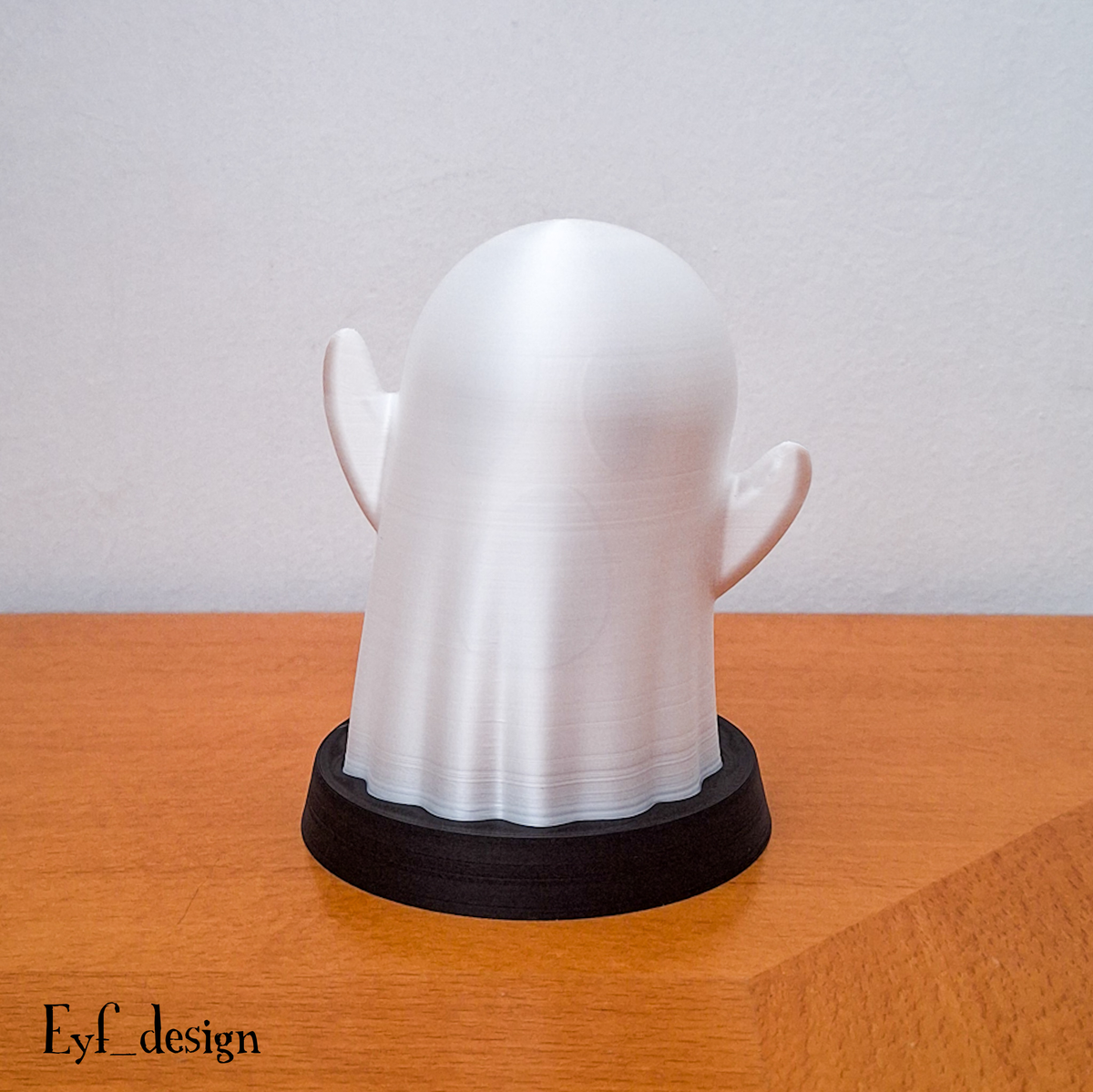 Smooth featureless white ghost lamp on a black round base, switched off