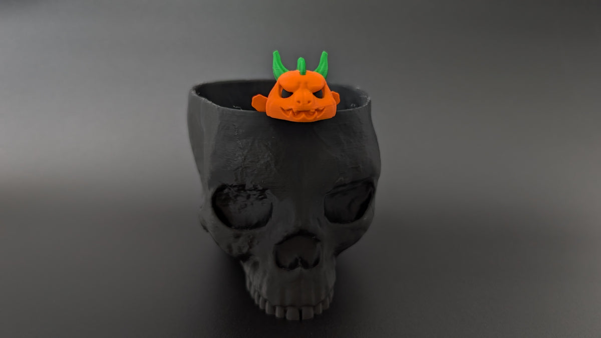 Pumpkin dragon beside Halloween skull prop