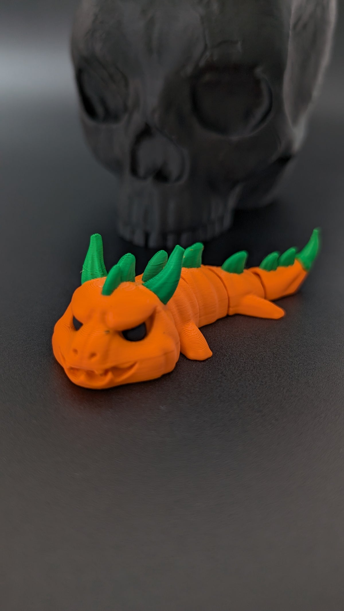 Pumpkin dragon beside skull