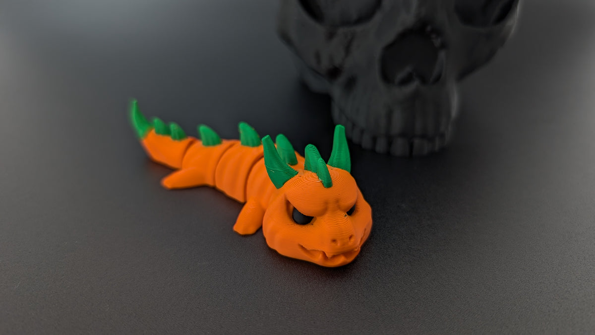 Pumpkin dragon peeking over skull prop