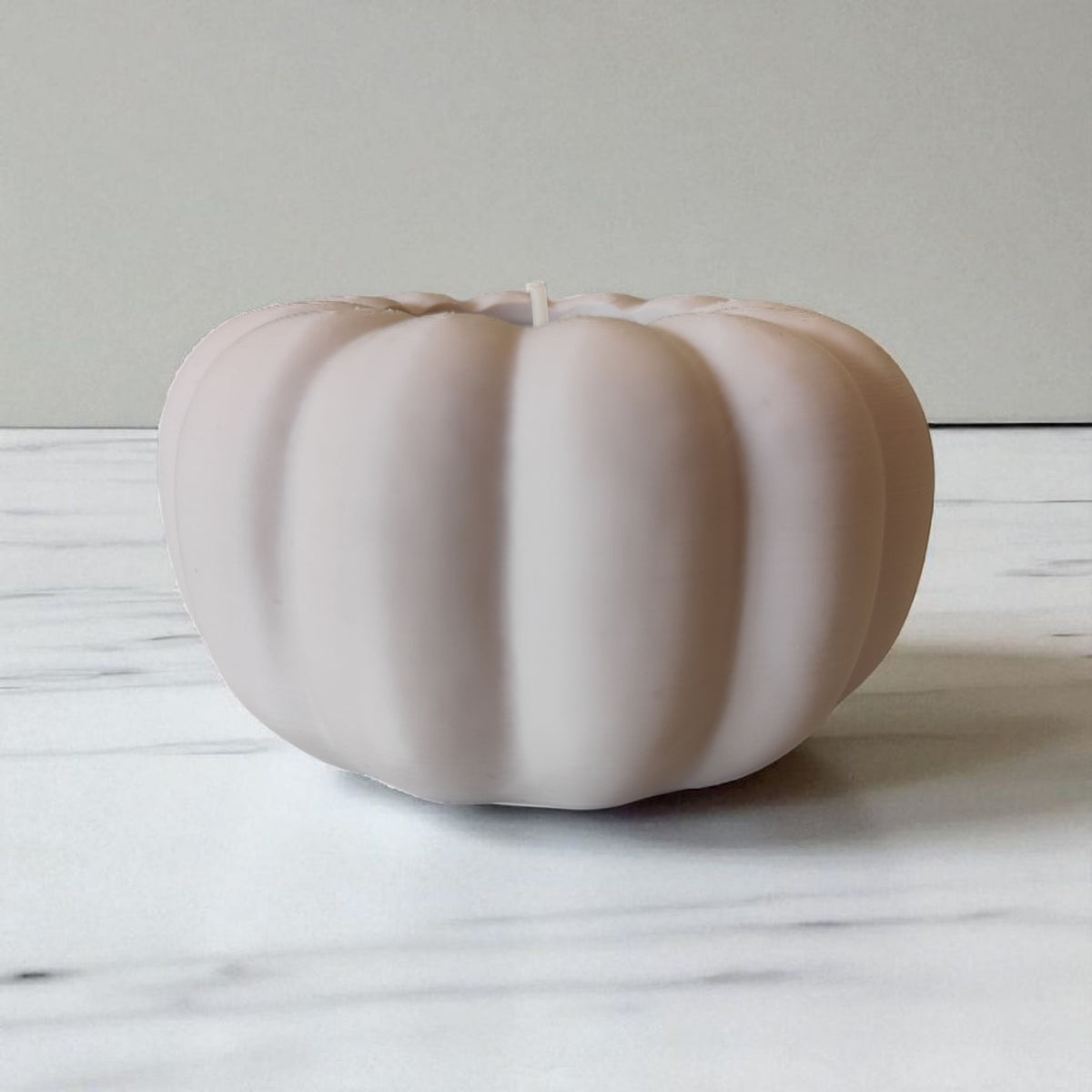 Two autumn pumpkin tealight holders beige and white beside green plant lifestyle