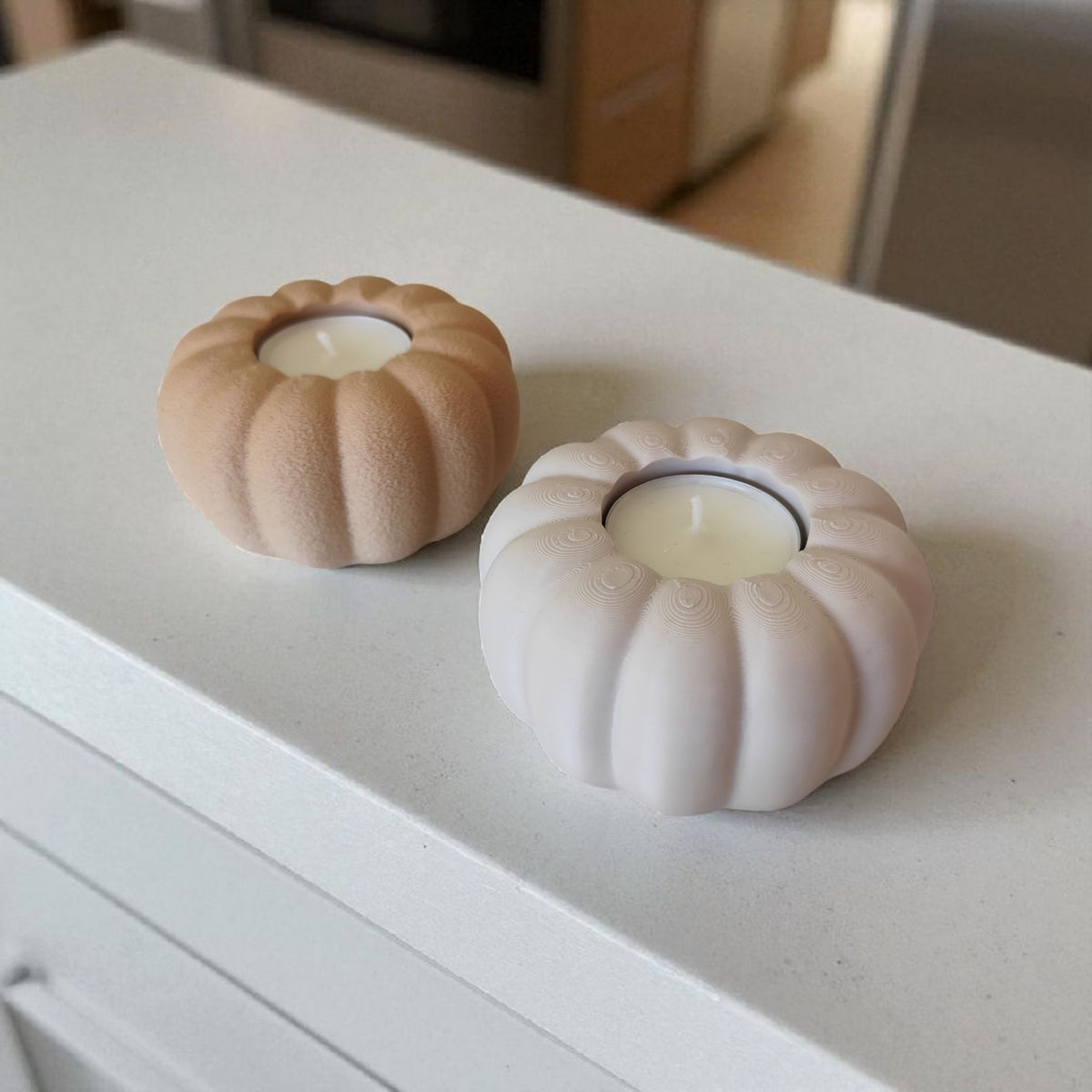 Two autumn pumpkin tealight holders beige and white on rustic wood close up lifestyle