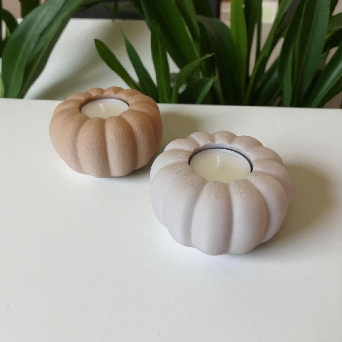 Two autumn pumpkin tealight holders beige and white on dark wood angled lifestyle