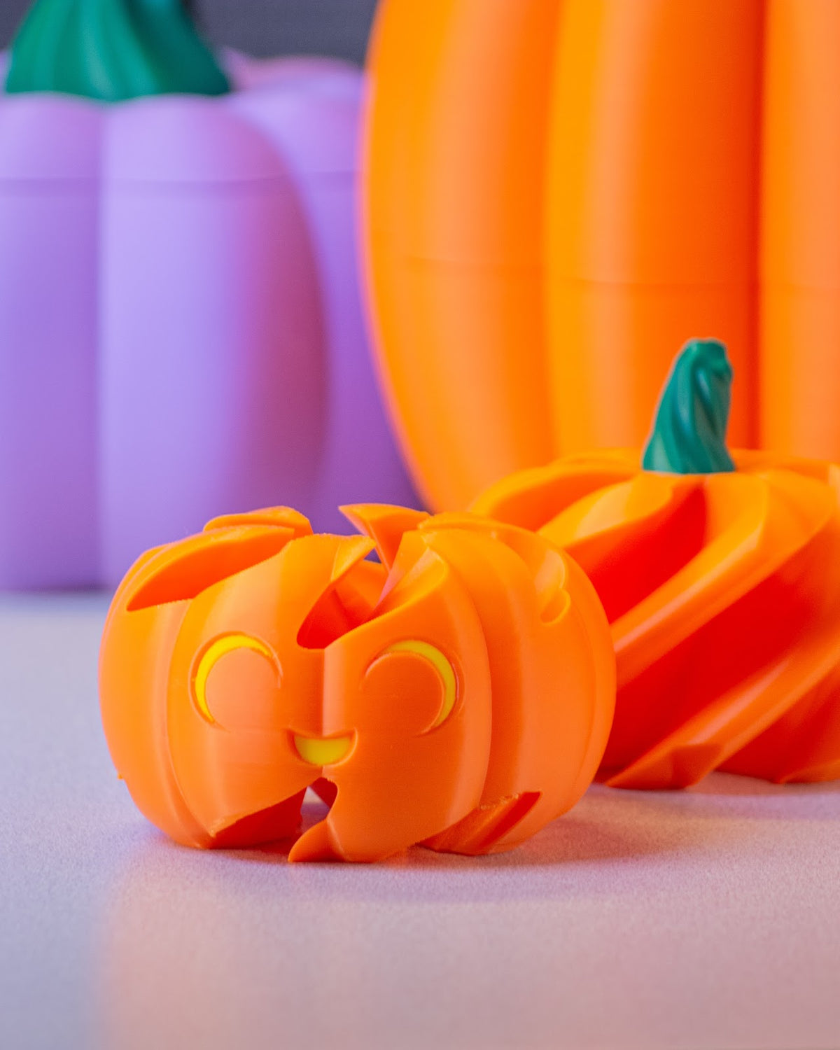 Orange segmented spiral pumpkin puzzle with a smiling face and green stem