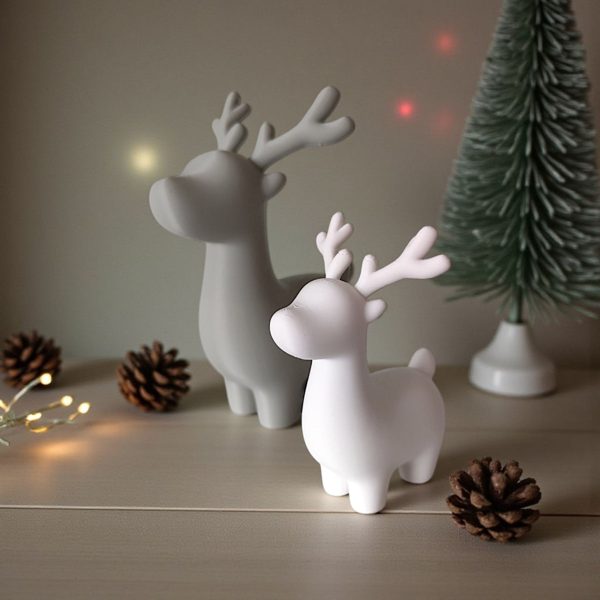 Grey and white reindeer pair on white marble surface product shot