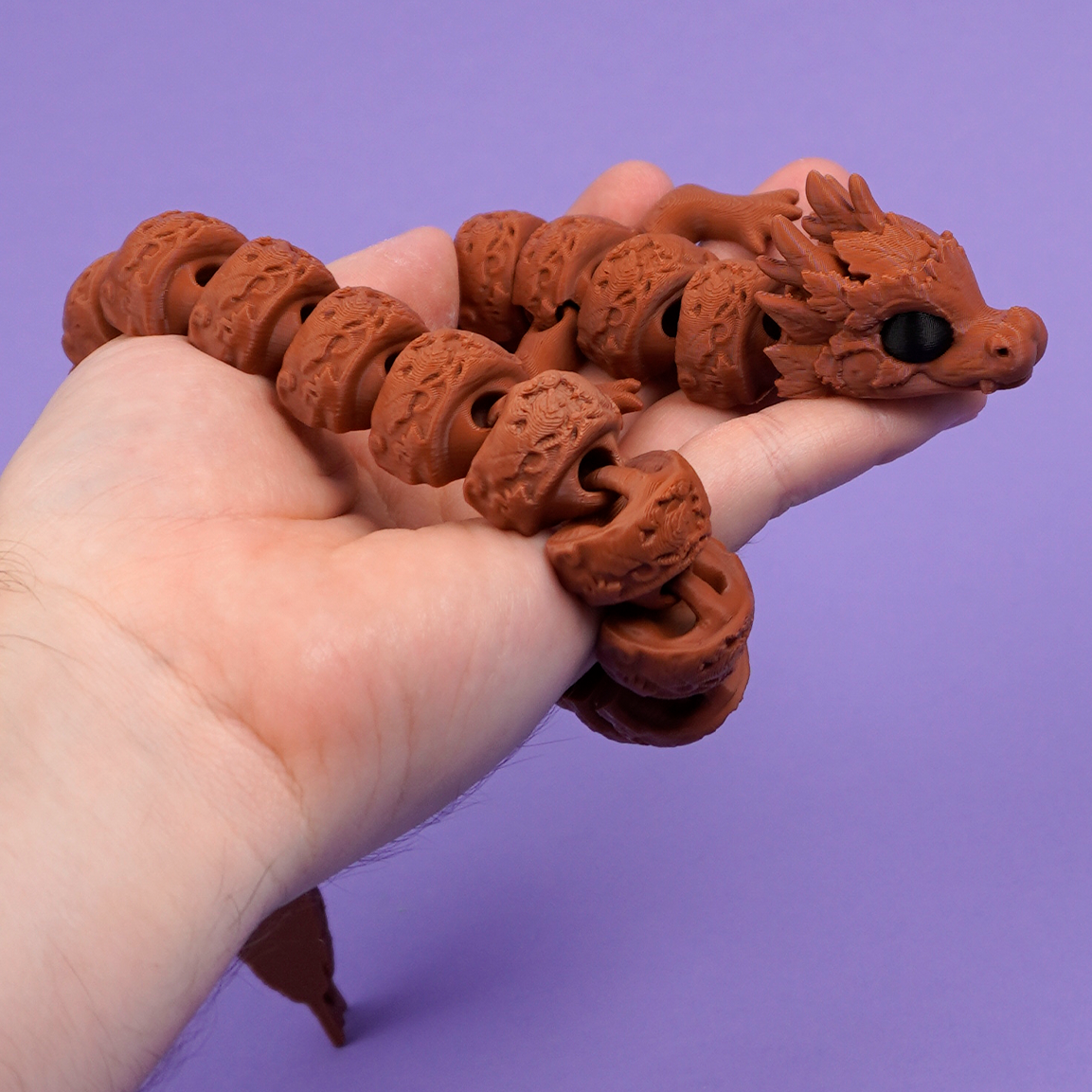 Articulated autumn dragon curled on lilac backdrop