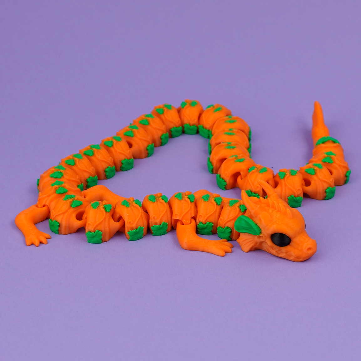 Orange articulated Pumpkin Dragon stretched out on purple background