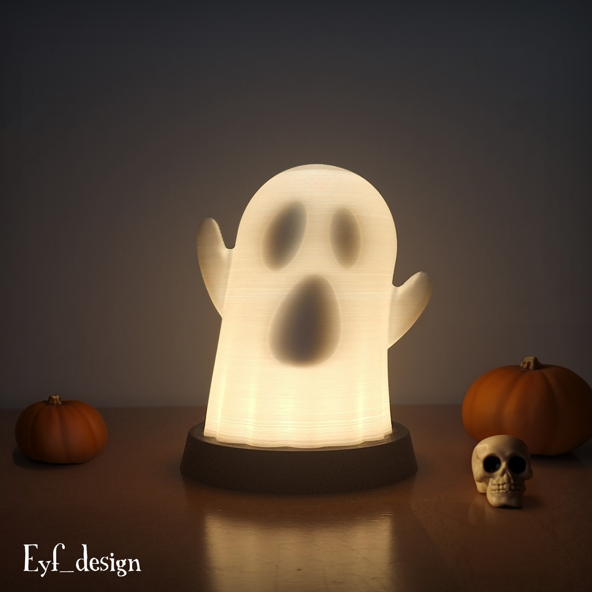 Glowing cartoon ghost lamp displayed with pumpkins for Halloween