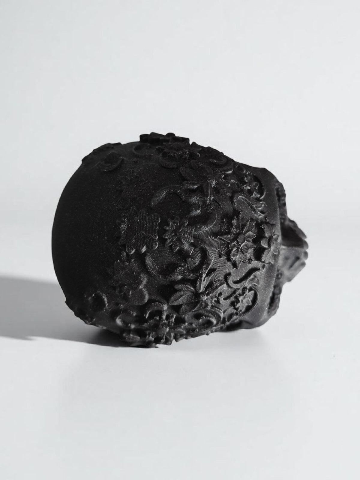 Matte black ornamental skull rear view showing all-over intricate relief detail