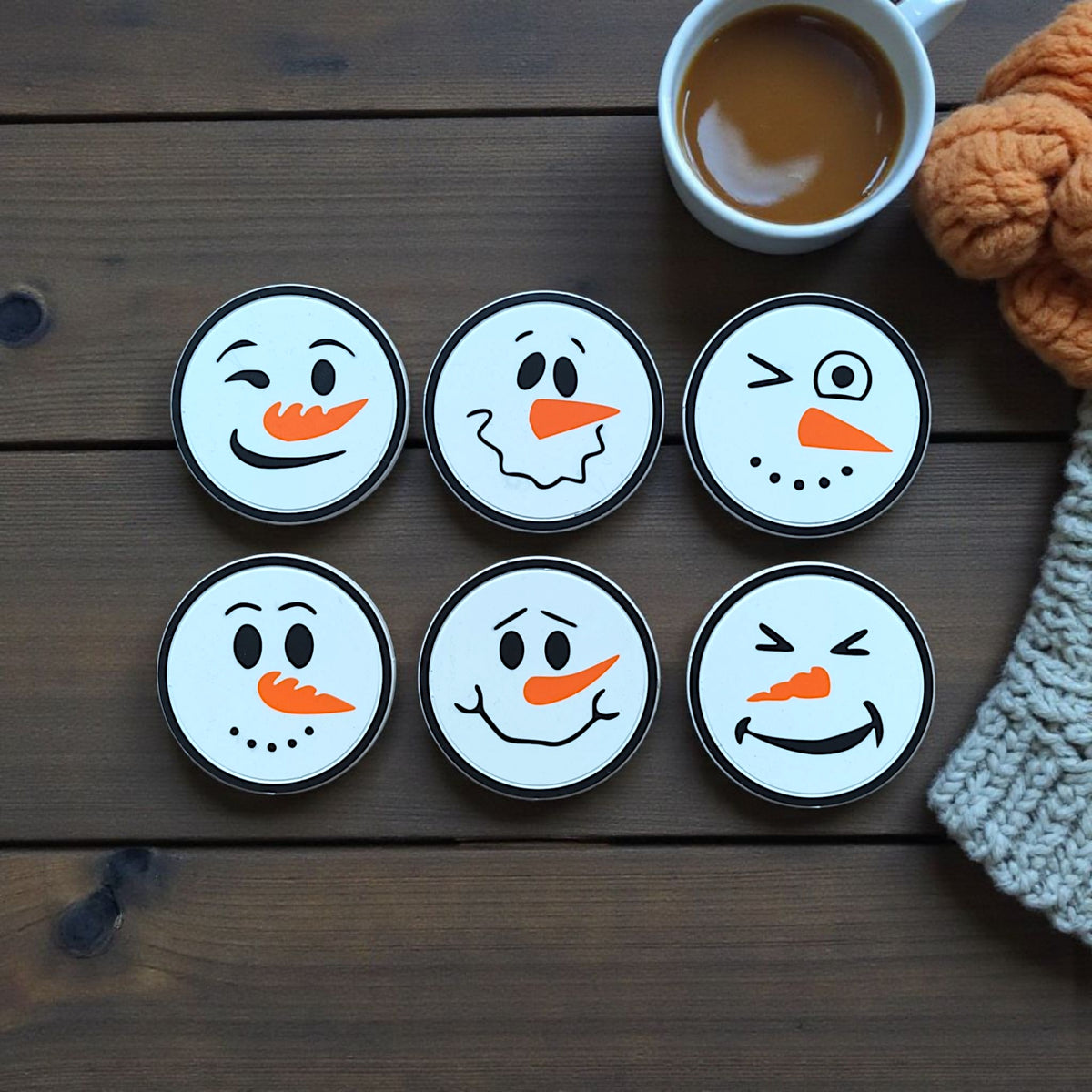 Six funny snowman faces arranged around mug