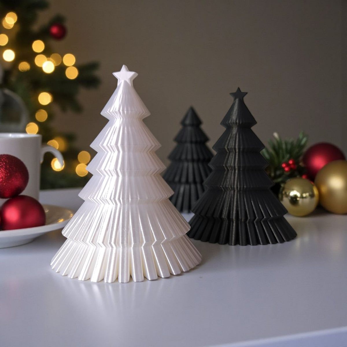 White and black ribbed Christmas tree duo on window sill with snowy winter background