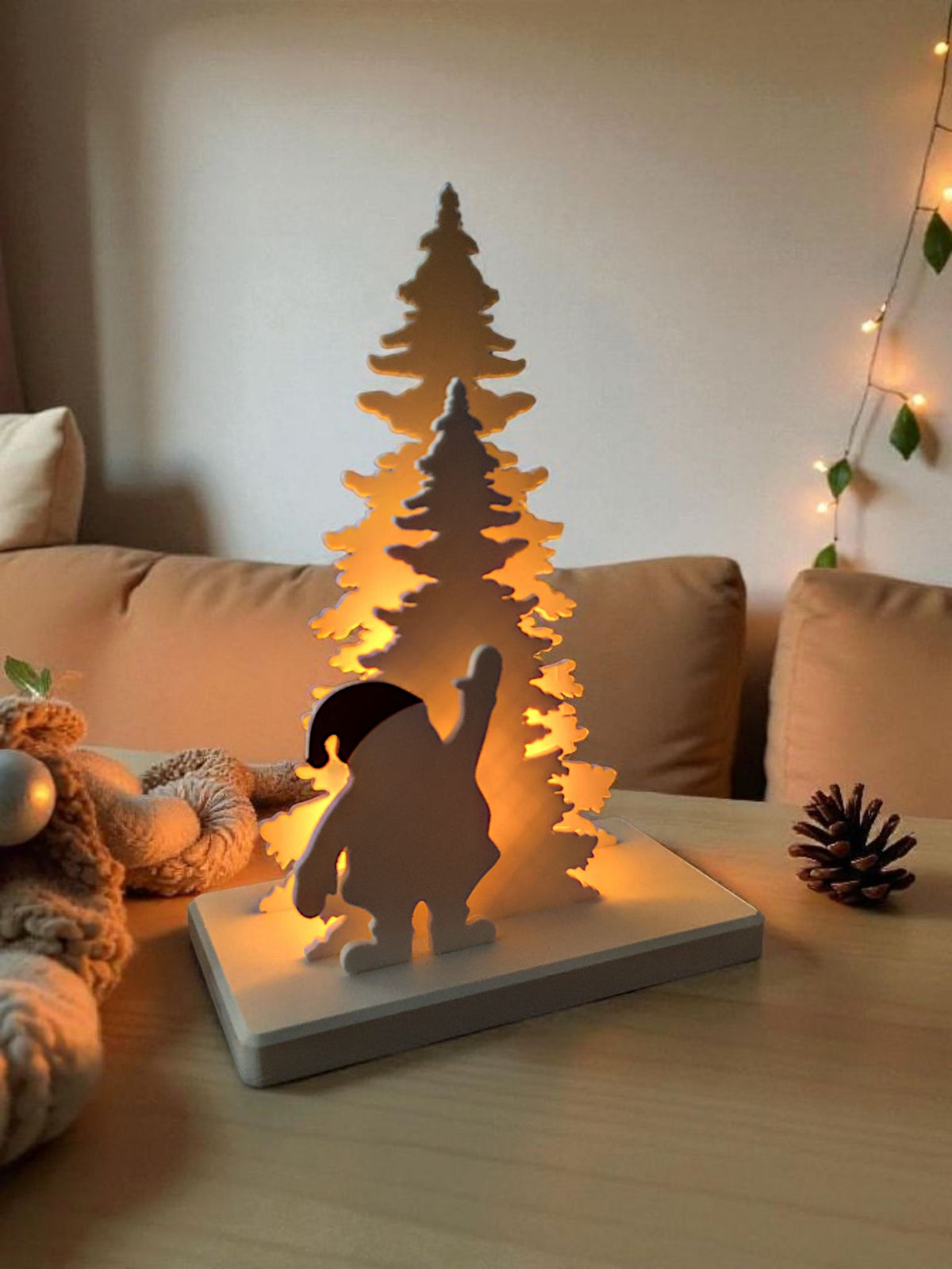 Santa Claus tree scene glowing warm on wooden table cosy living room fireplace side view
