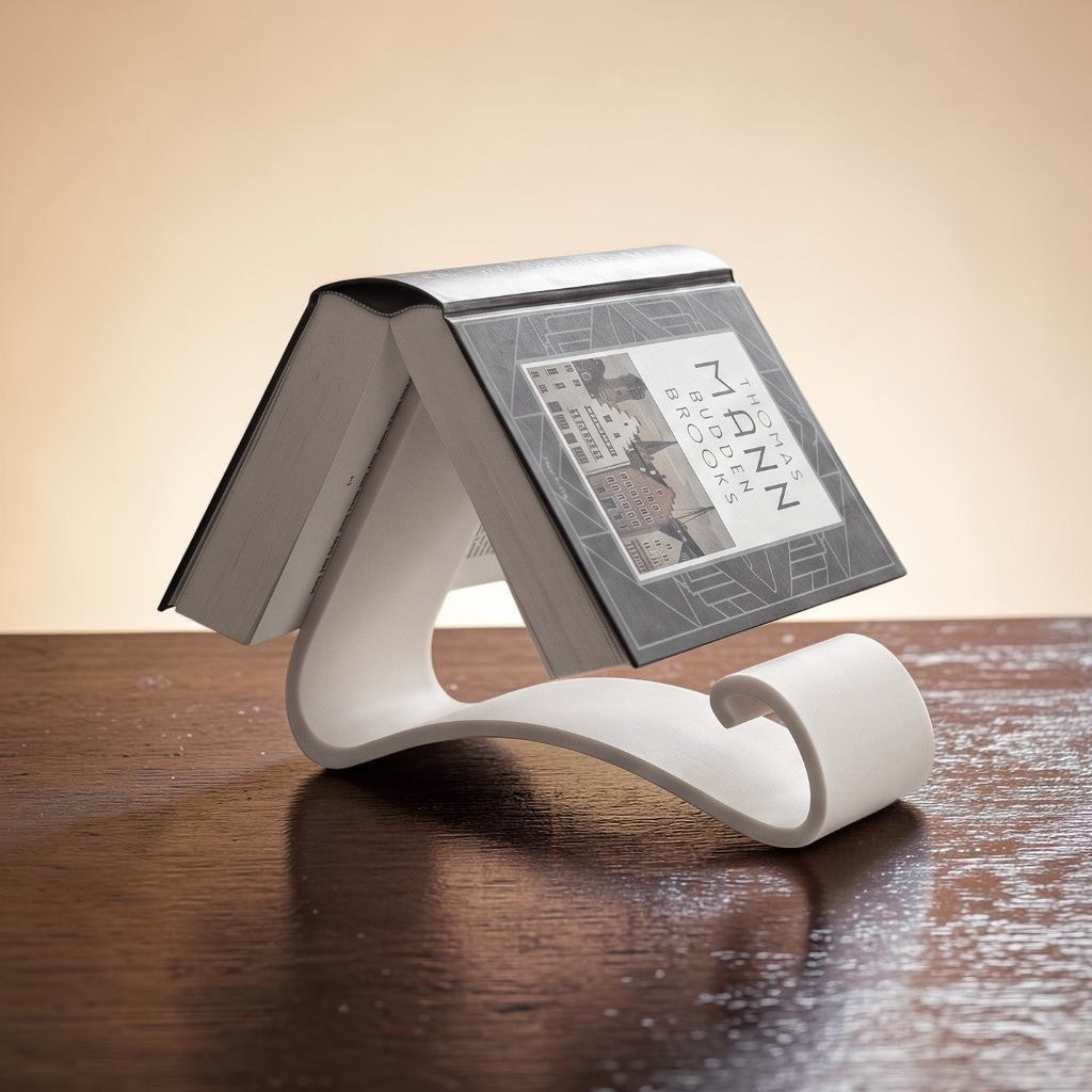Wavy Book Stand in white holding a book upright on a wooden desk, lifestyle view