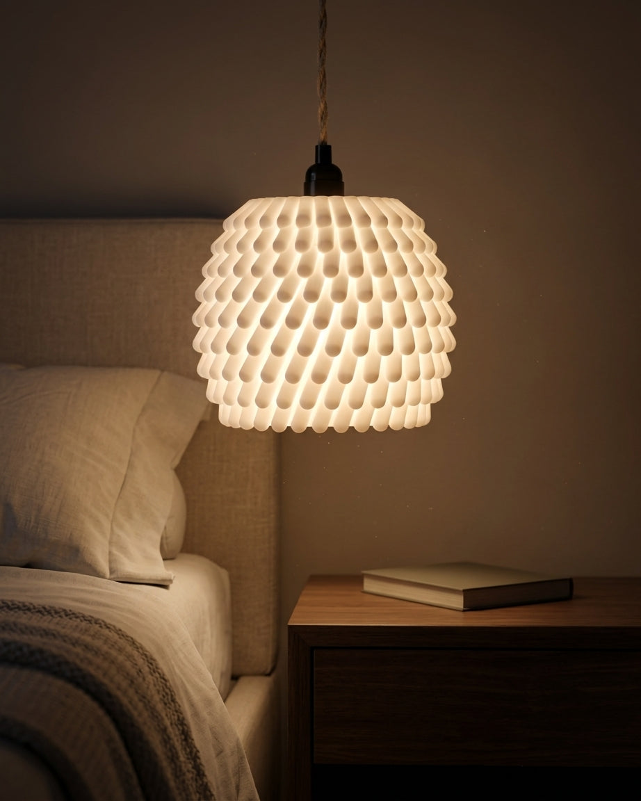 Three sea anemone pendant lampshades in graduated heights glowing over oak dining table lifestyle