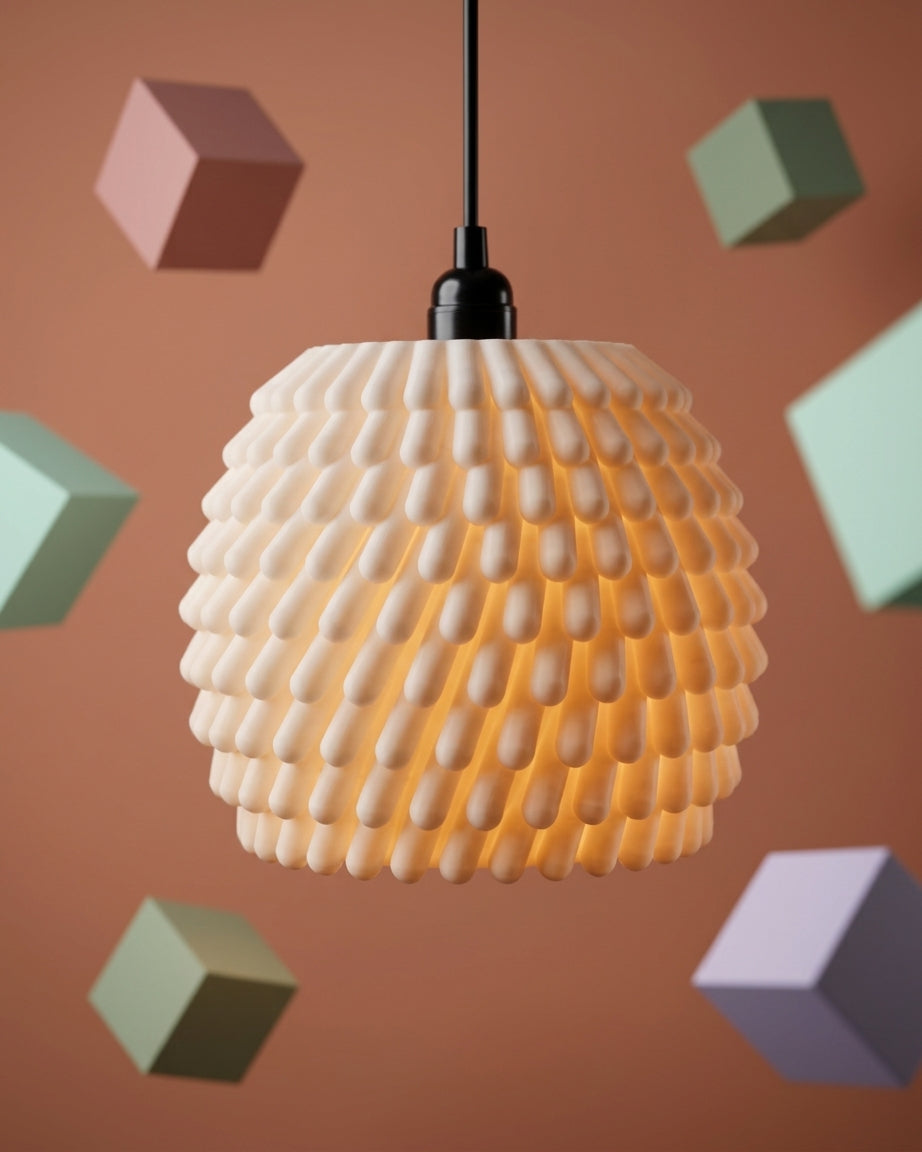 Sea anemone pendant lampshade glowing warm amber on black background product shot