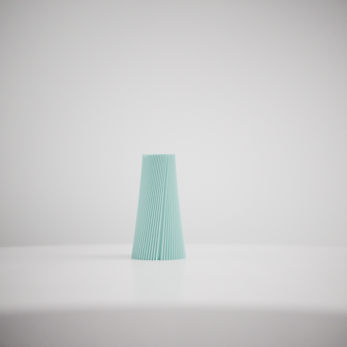 Pleated Cone Vase mint green on warm oak sideboard beside dark ceramic vase and books moody backdrop