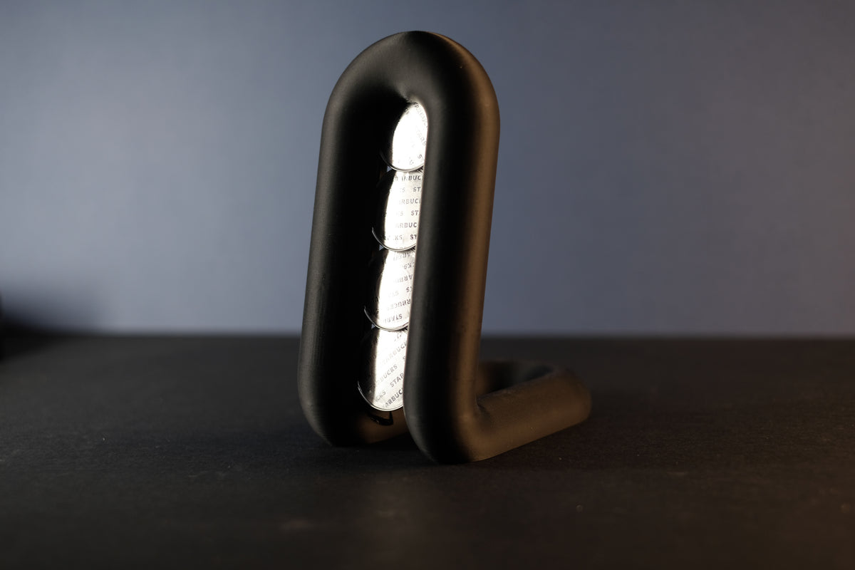 Matte black wibble arch pod holder base render showing smooth loop form