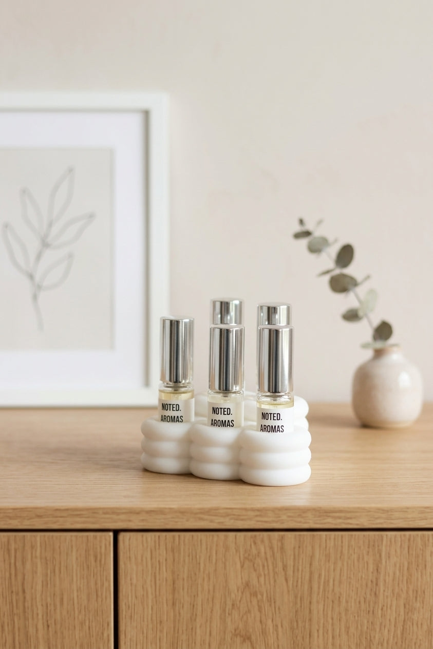 Cloud Perfume Sample Stand white on dark wooden sideboard with gold vase monstera dark editorial