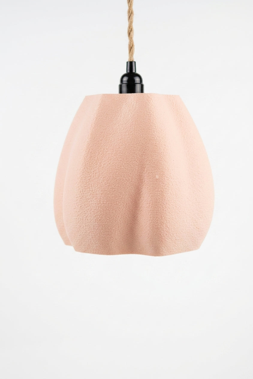 Organic flowing pendant lamp shade pink terracotta on kraft paper with jute rope eucalyptus and white ceramic shards flat lay lifestyle