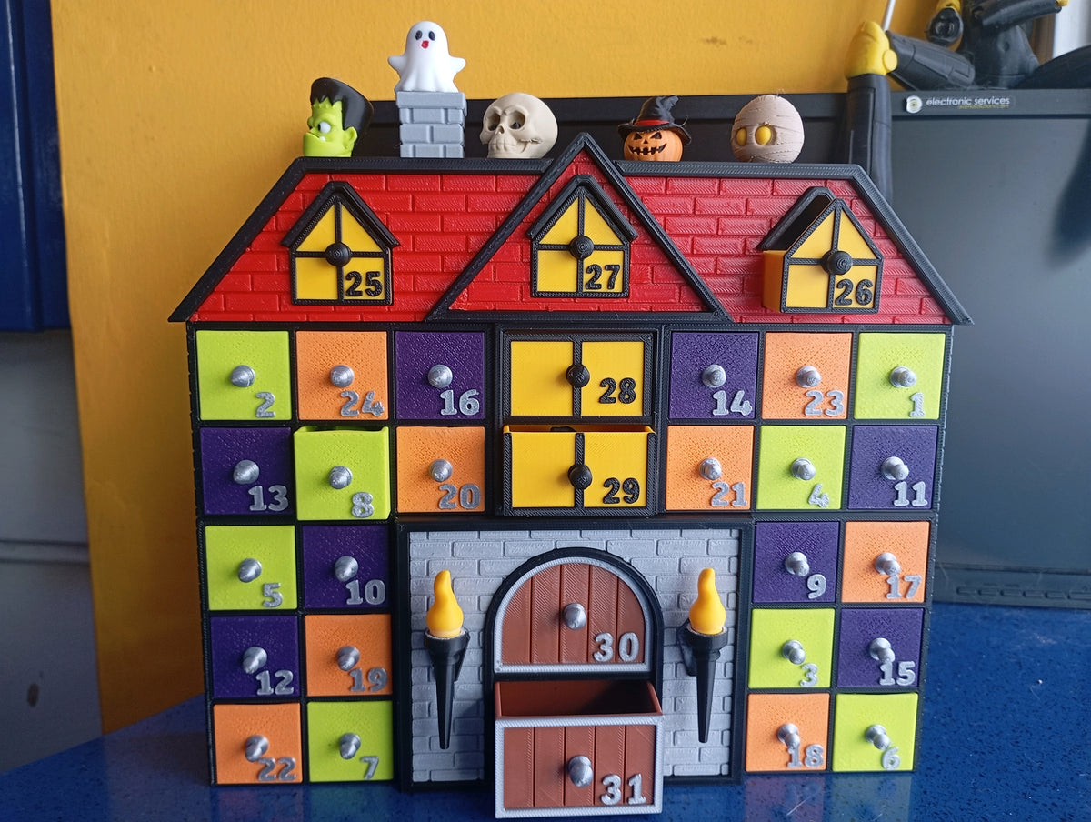 Halloween advent calendar house with numbered drawers and a ghost on the roof
