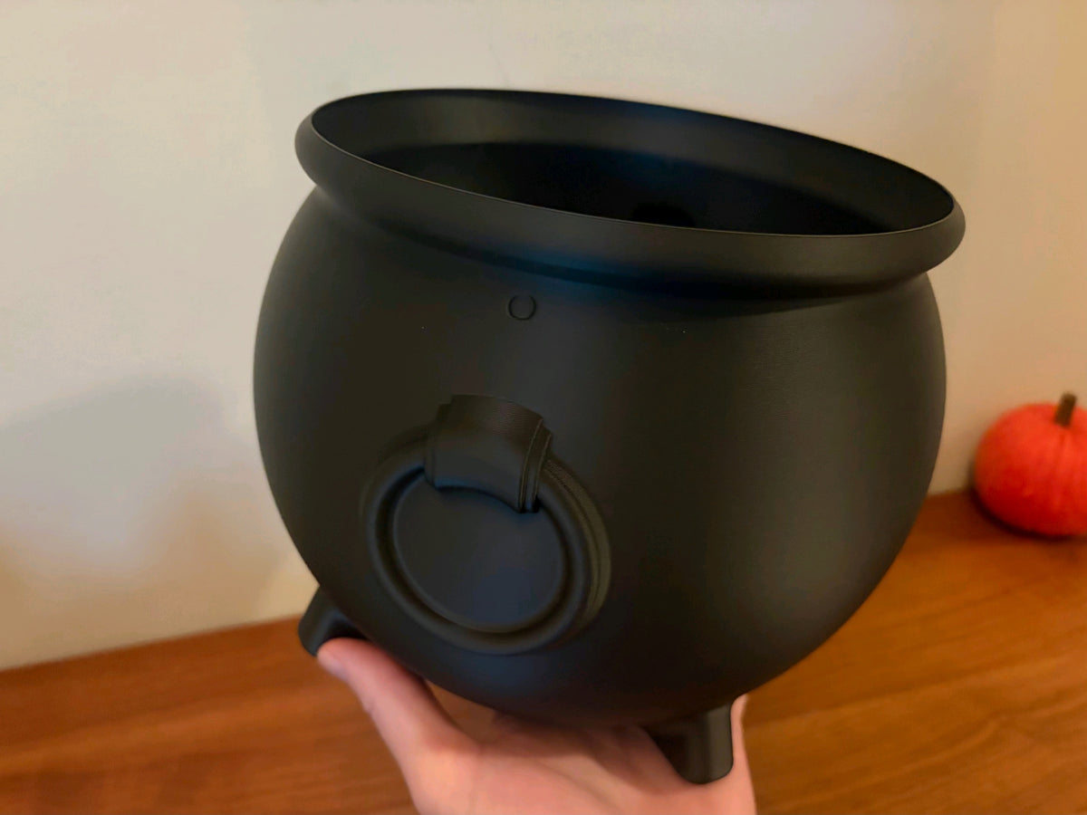 Black cauldron tray shown with its arched handle