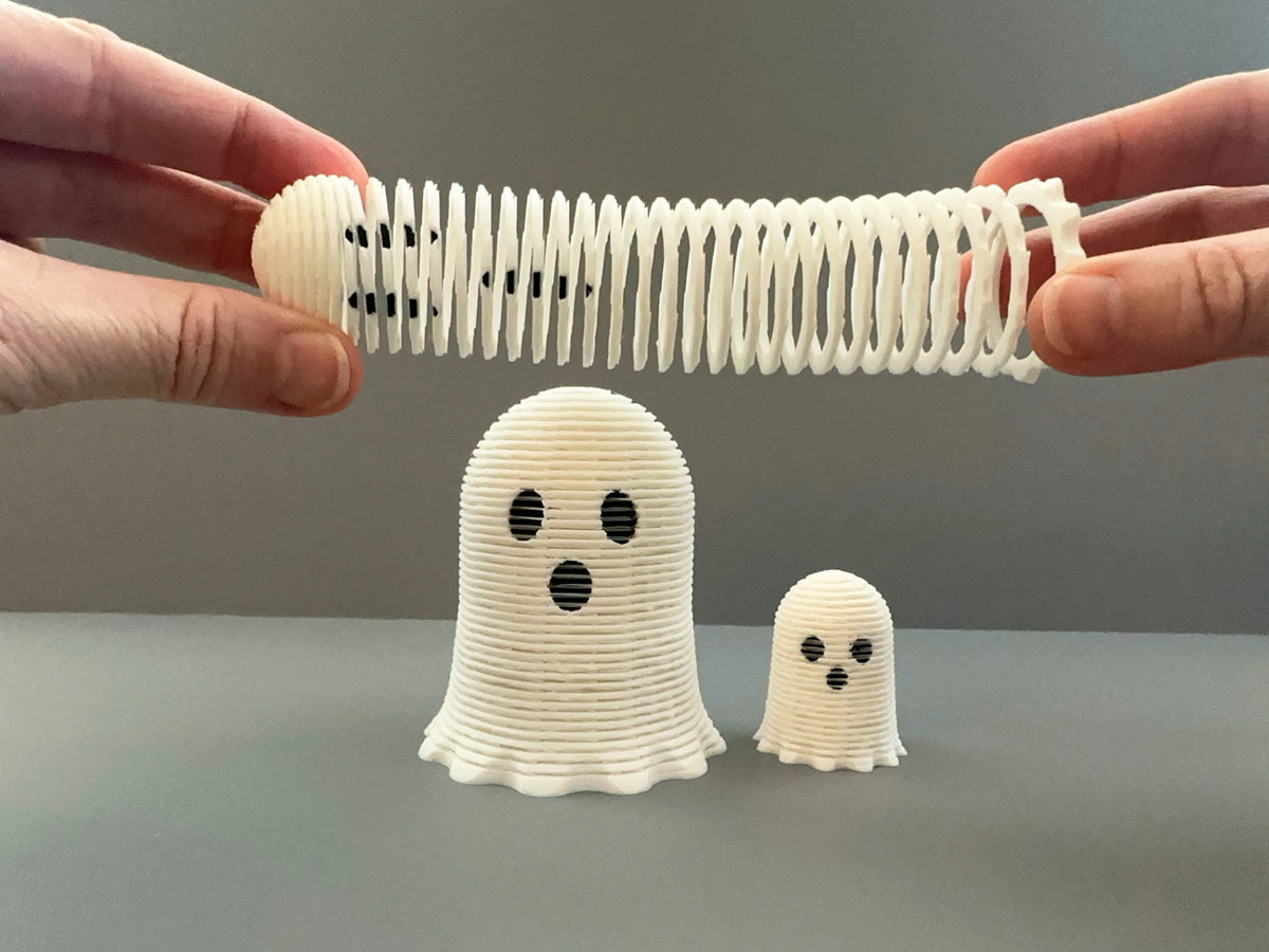 White ghost-shaped spring fidget shown compact and stretched