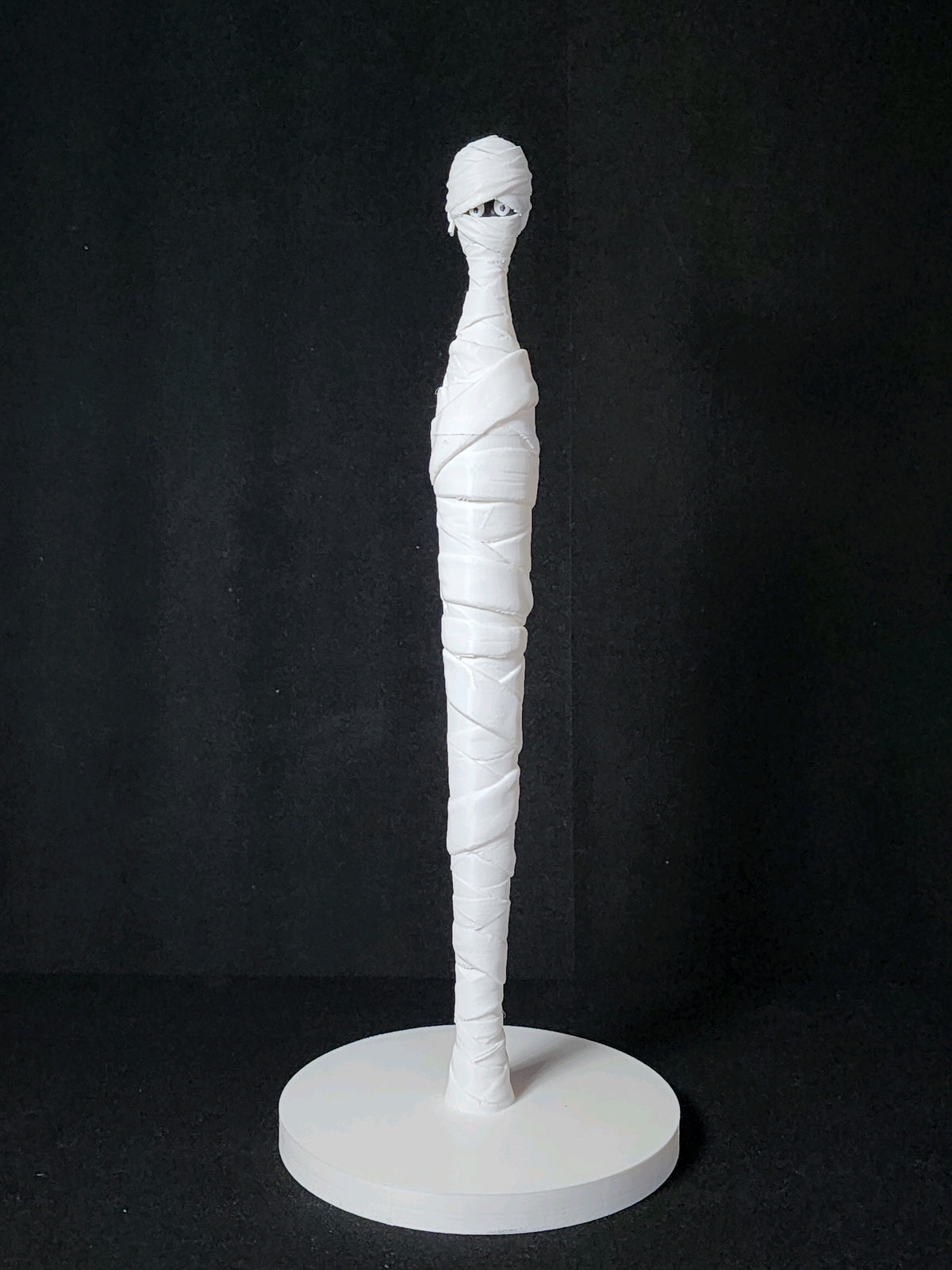 White bandage-wrapped mummy stand with a round base shown without a kitchen roll