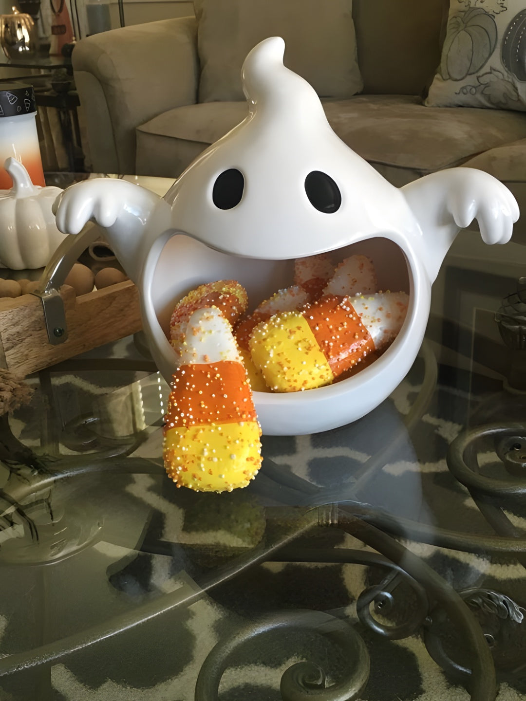 Glossy white ghost sweet bowl with wide mouth, dark eyes and outstretched hands holding sweets