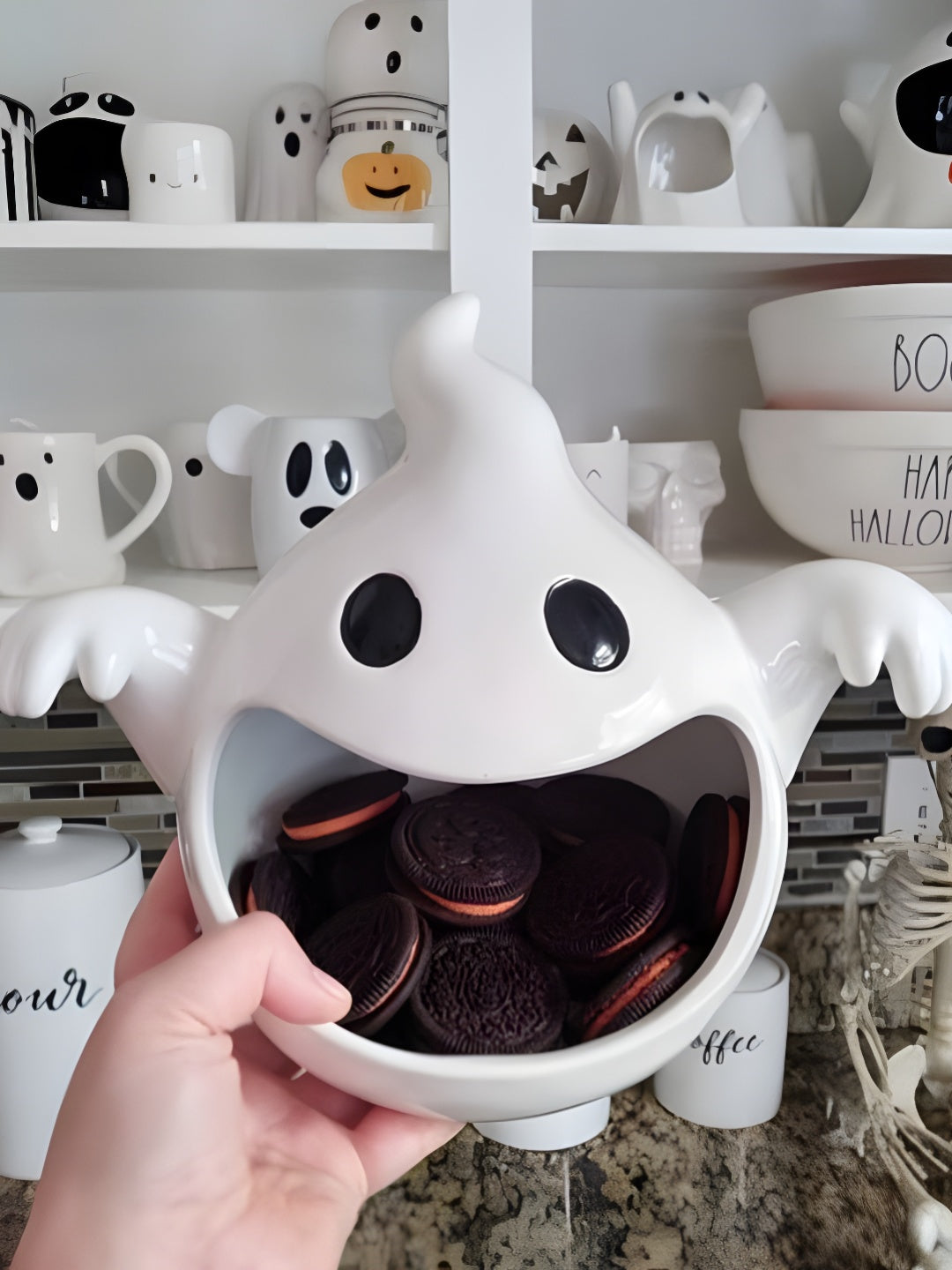 White ghost sweet bowl with curled head point and reaching arms, shown among Halloween displays