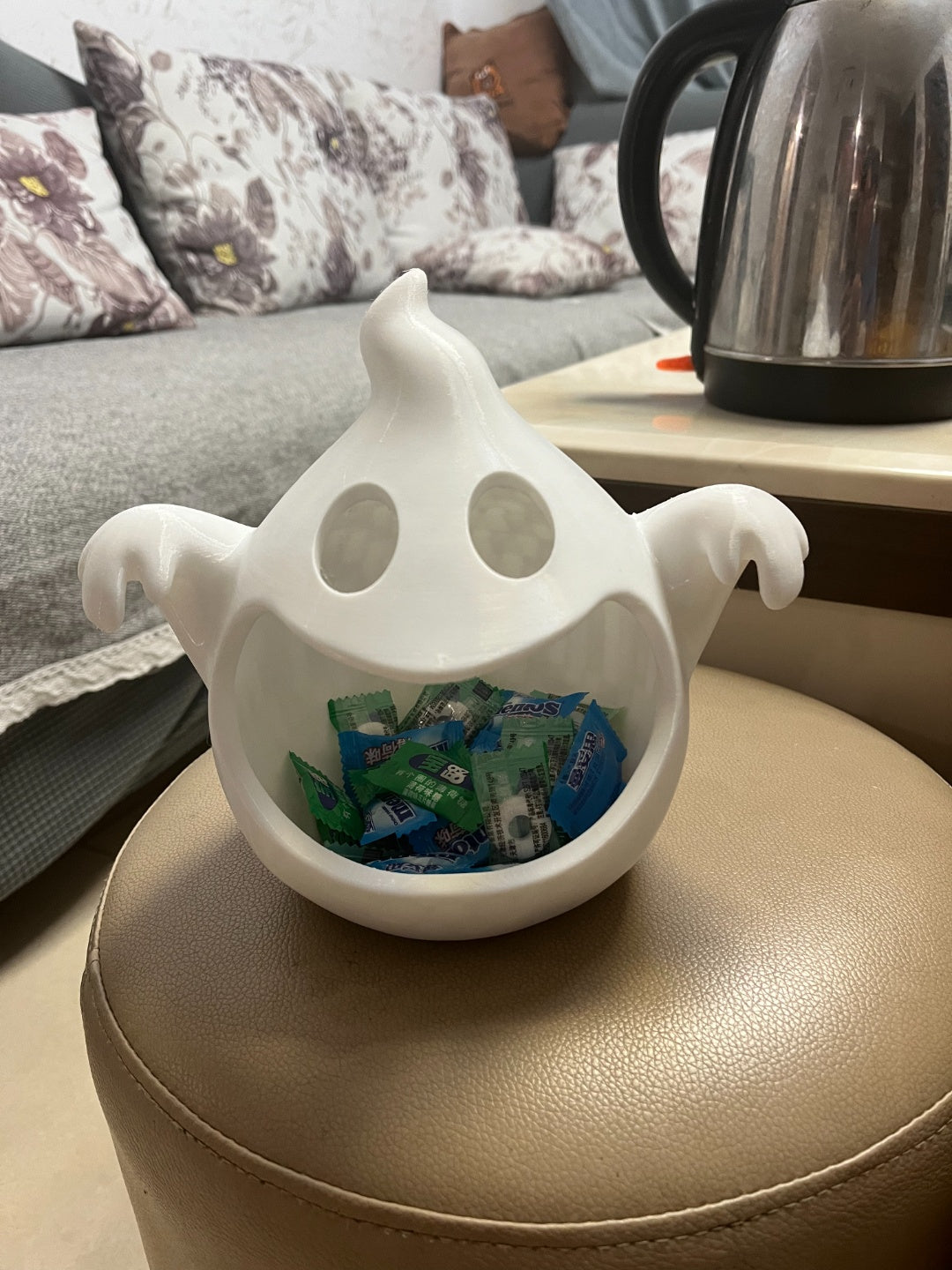 White reaching-arm ghost bowl filled with wrapped chocolate treats