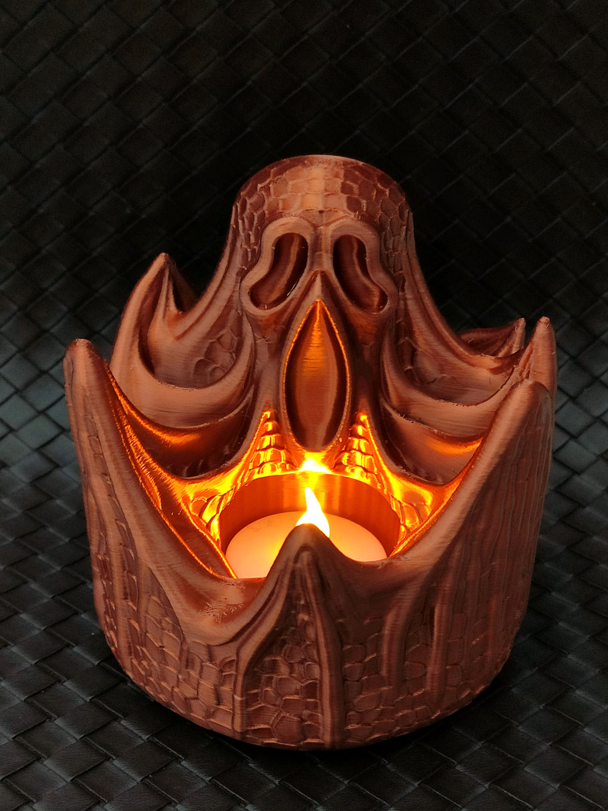 Brown gothic archway-shaped tealight holder with a spooky face and warm light
