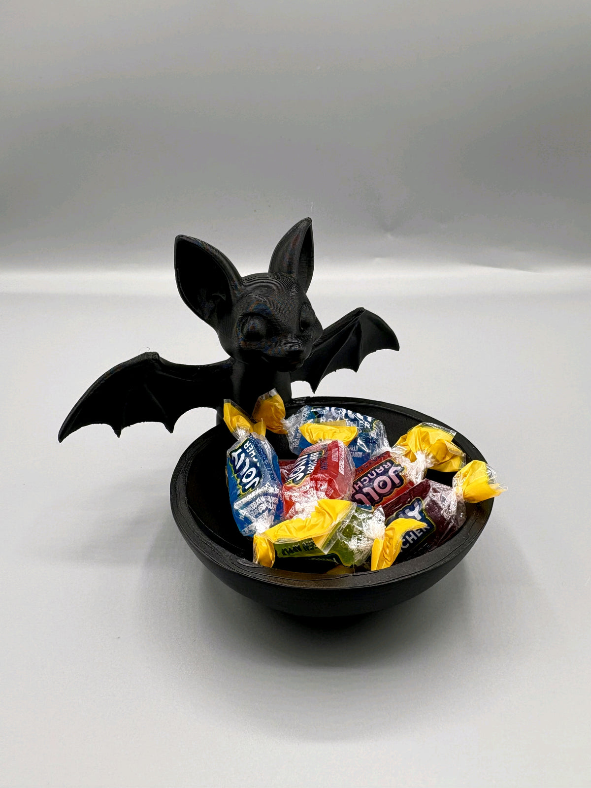 Black bat-shaped sweet tray with a shallow round bowl and outstretched wings