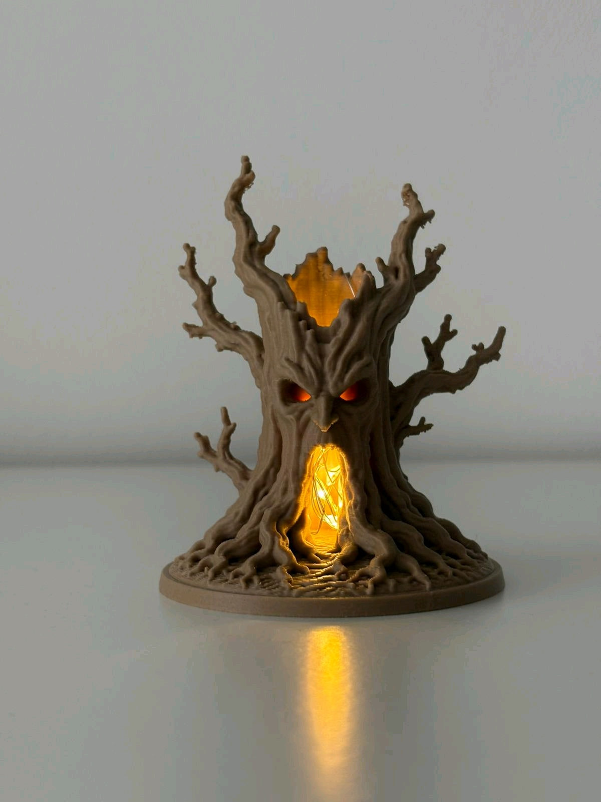 Unlit brown haunted tree tealight holder showing its twisting bare branches, face and hollow doorway