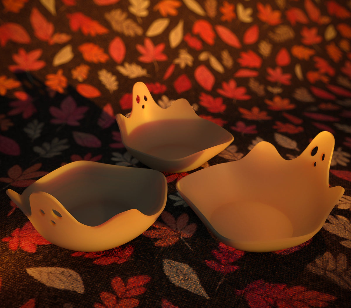 Angled view of an empty white ghost-shaped sweet tray beside warm decorative lights