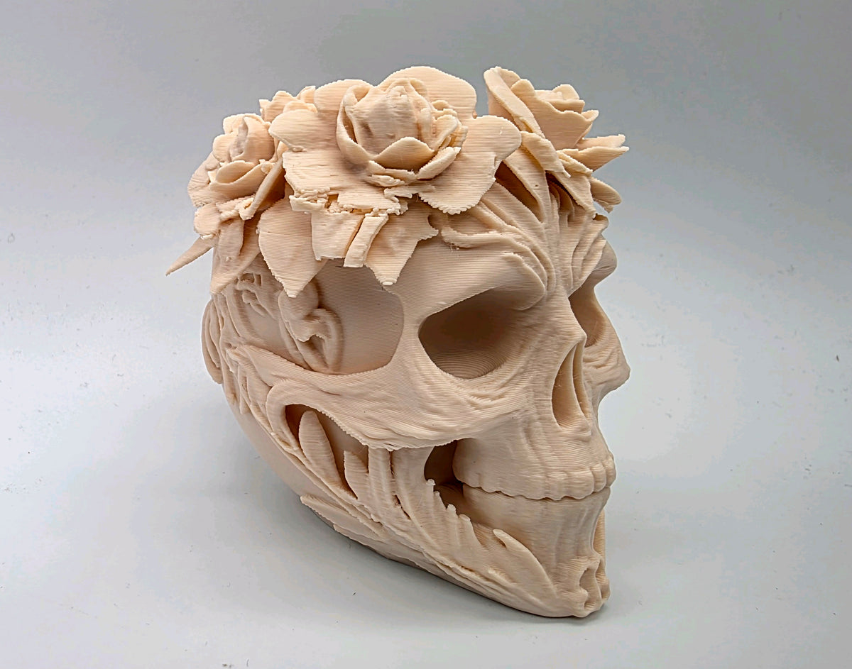 Angled view of flower-crowned skull with leaves and sculpted vines