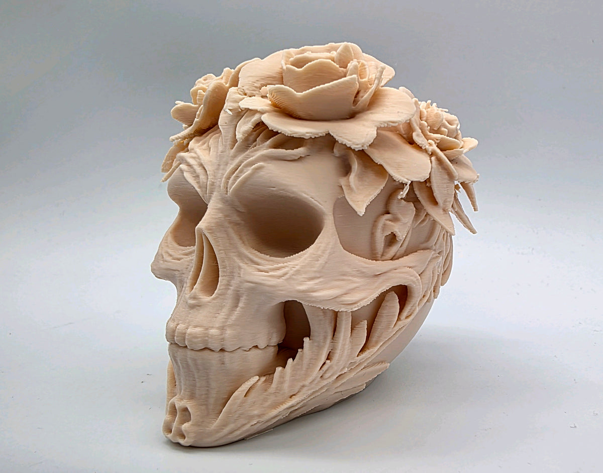Side view of pale skull with sculpted flowers and foliage wrapping the jaw