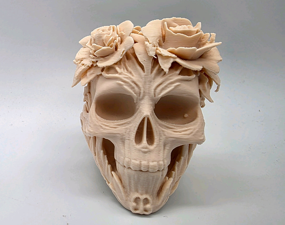 Front view of skull sculpture topped with sculpted flowers