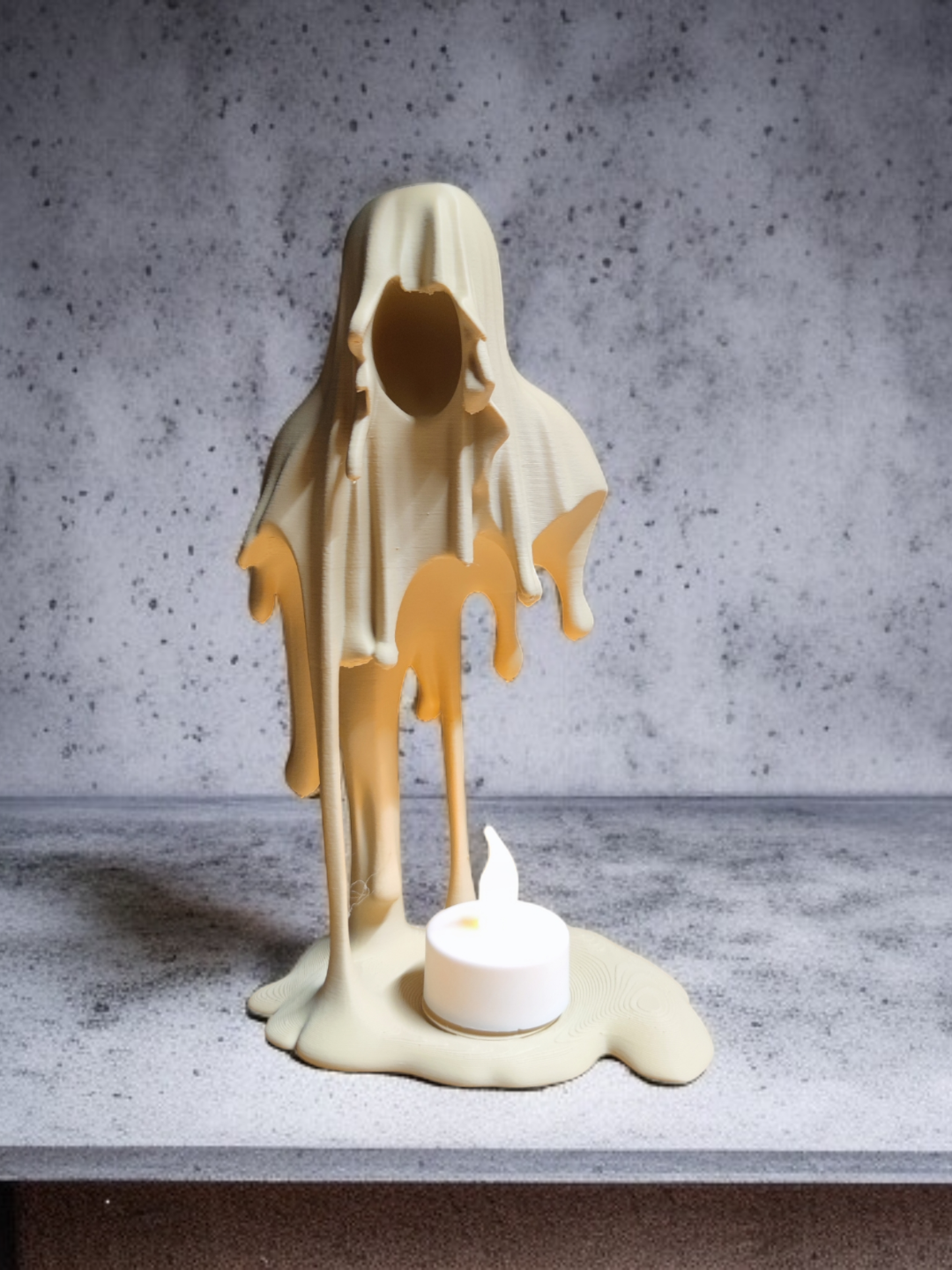 Pale hooded Grim Reaper tealight holder with a dark faceless opening and tealight at its feet