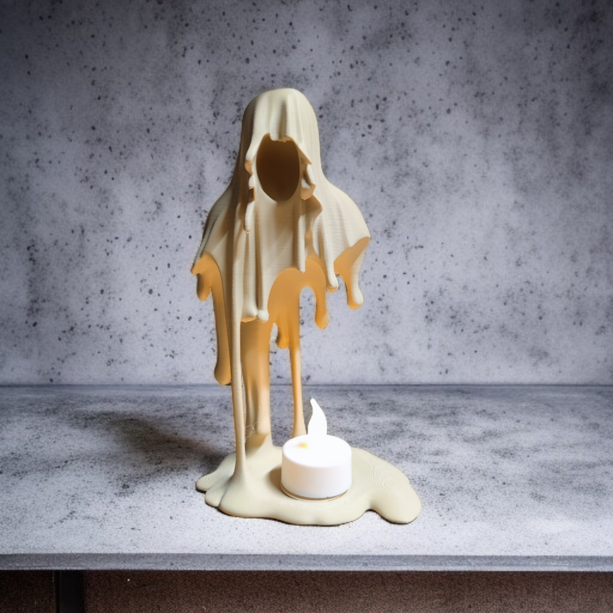 Front view of the pale Grim Reaper tealight holder with flowing robes and a tealight on its base